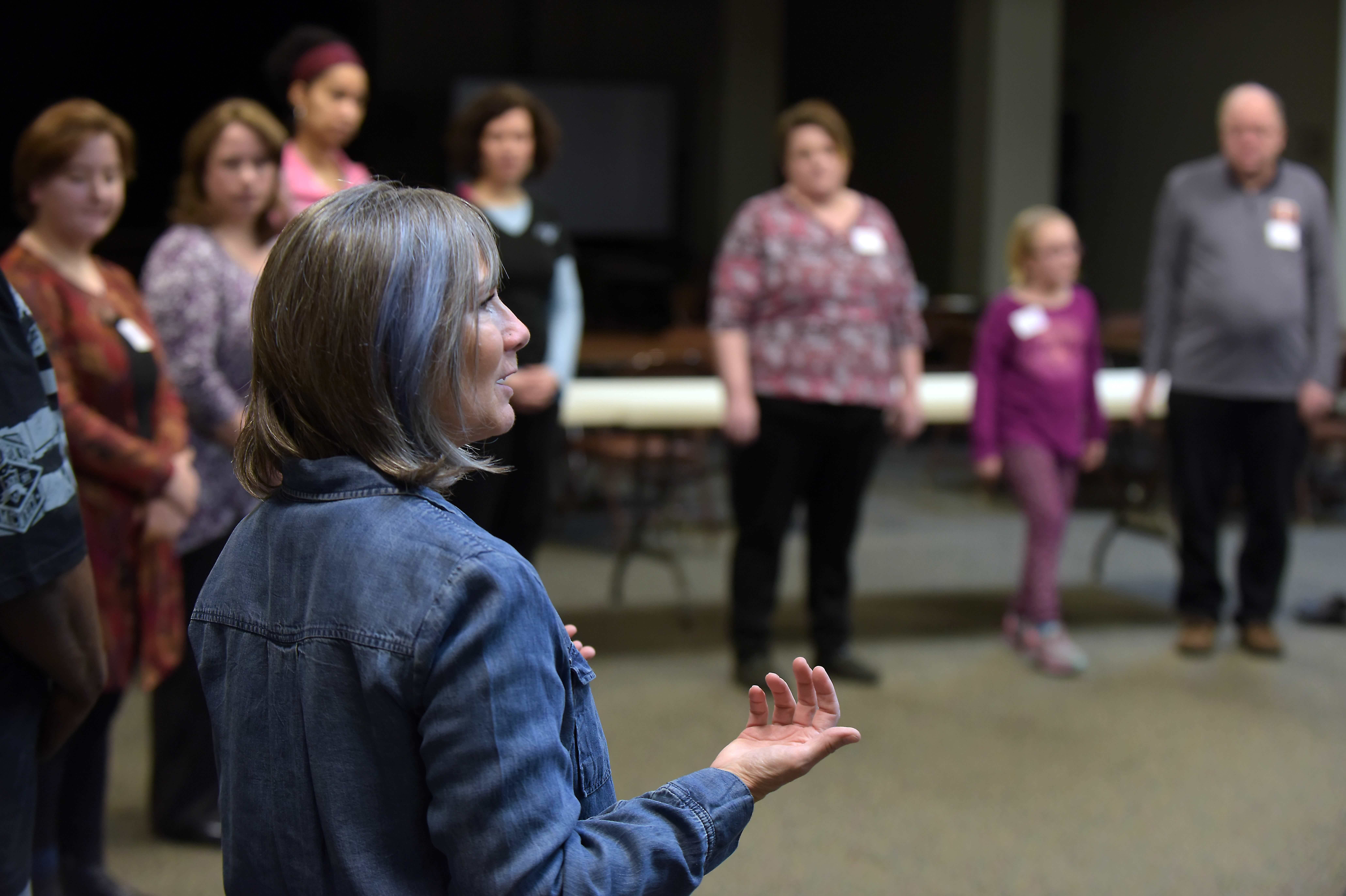 A woman speaking to a circle of people.