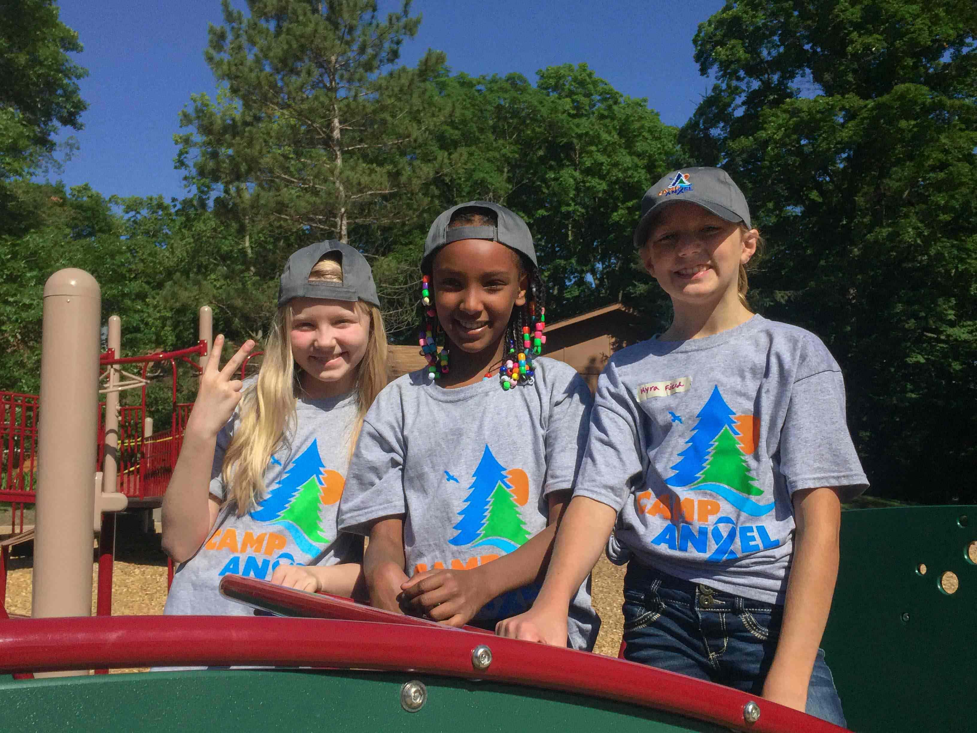 Three young girls smiling at Camp Angel