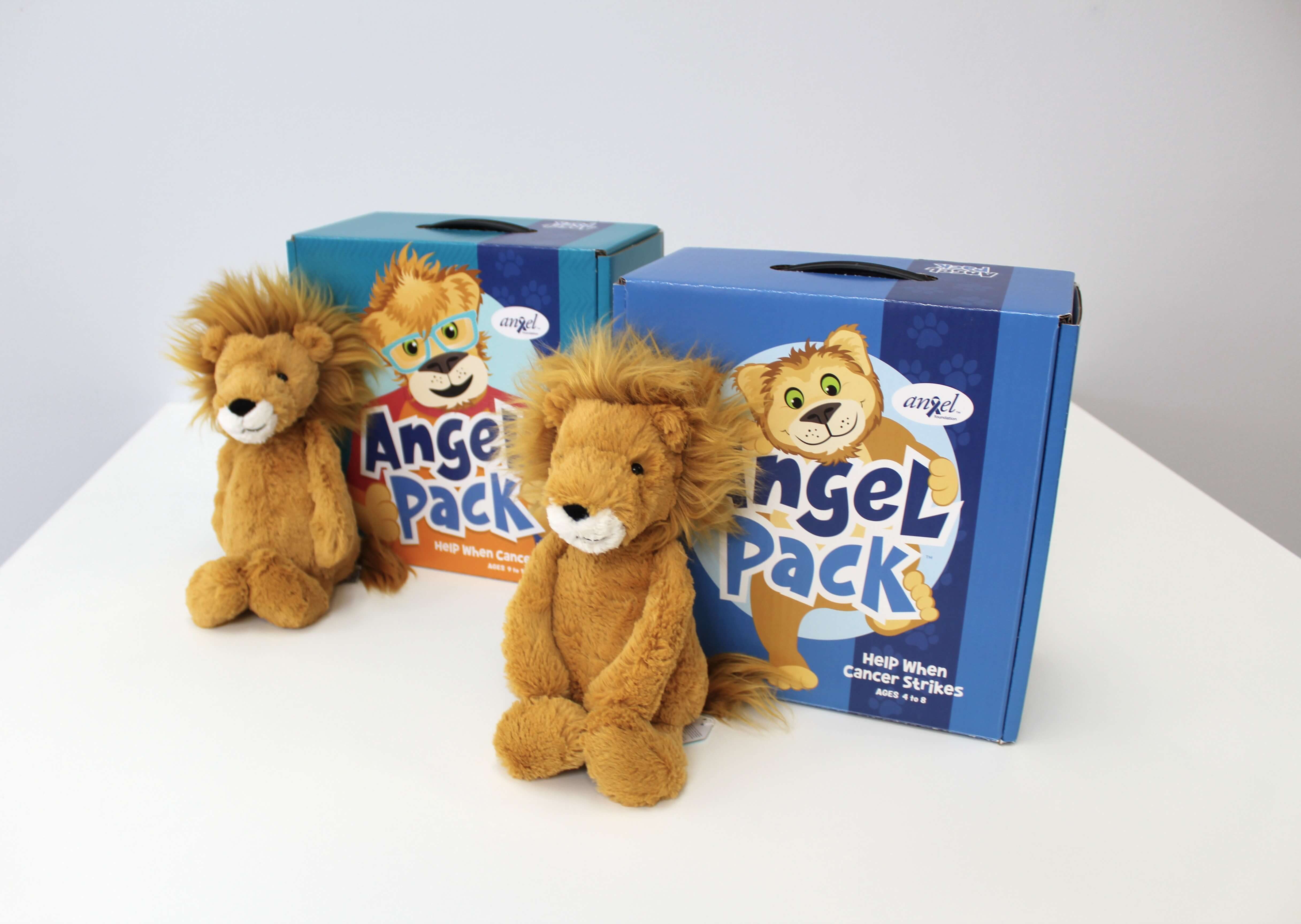 A side-by-side shot of the Child and Preteen Angel Packs with stuffed lions leaning on them.