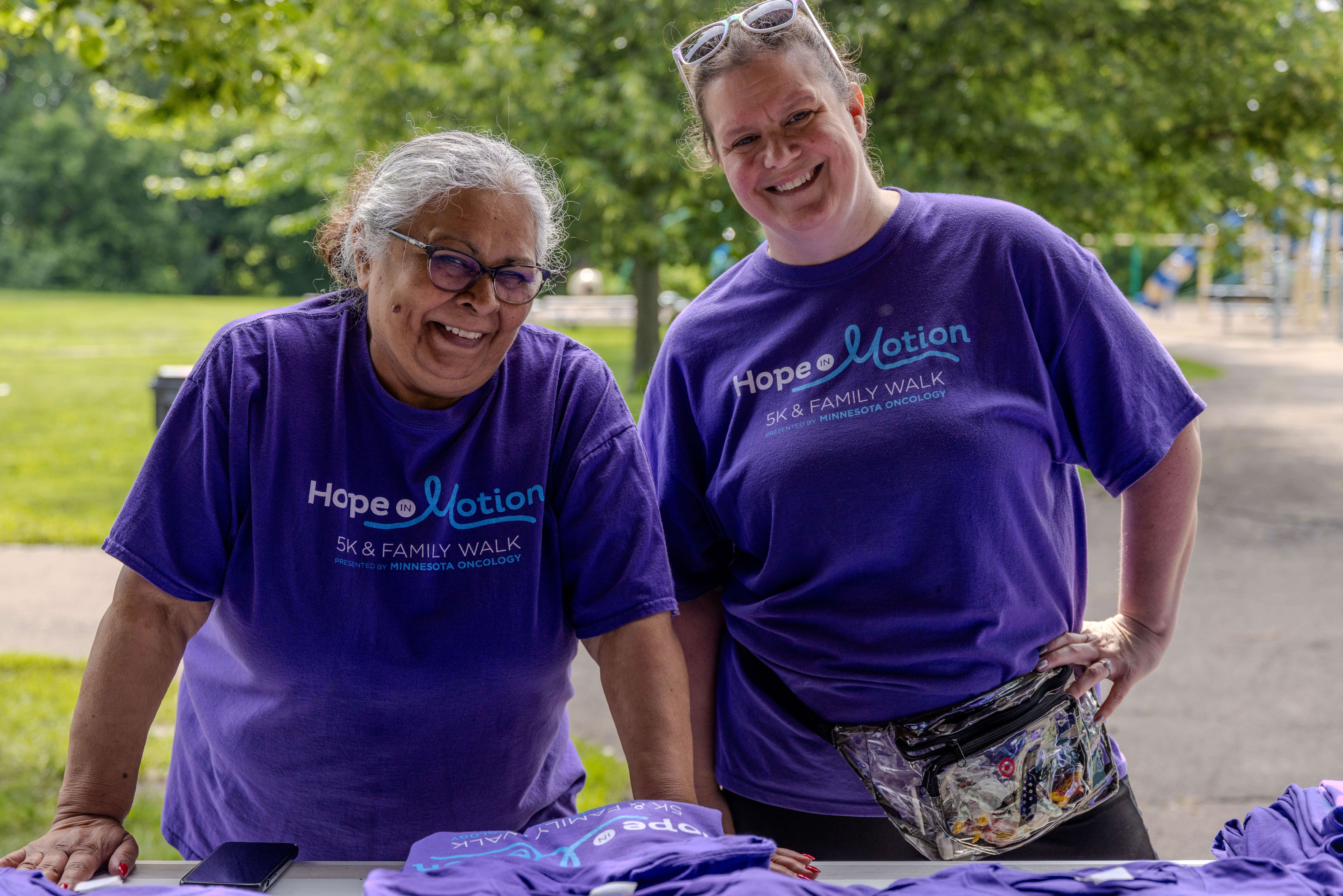 Two women wearing purple Hope in Motion T-shirts smiling