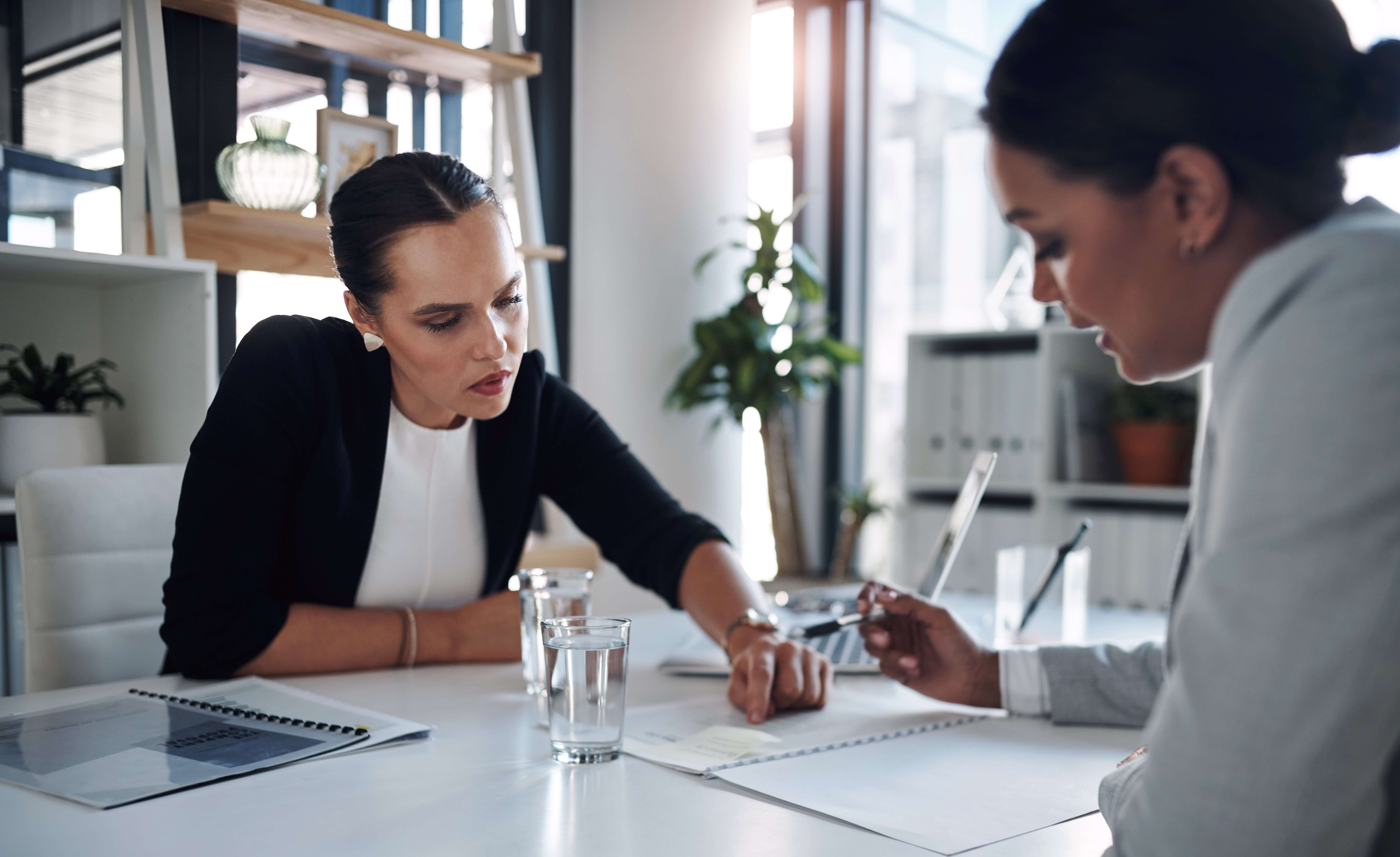 A Certified Financial Planner® and her client review paperwork.