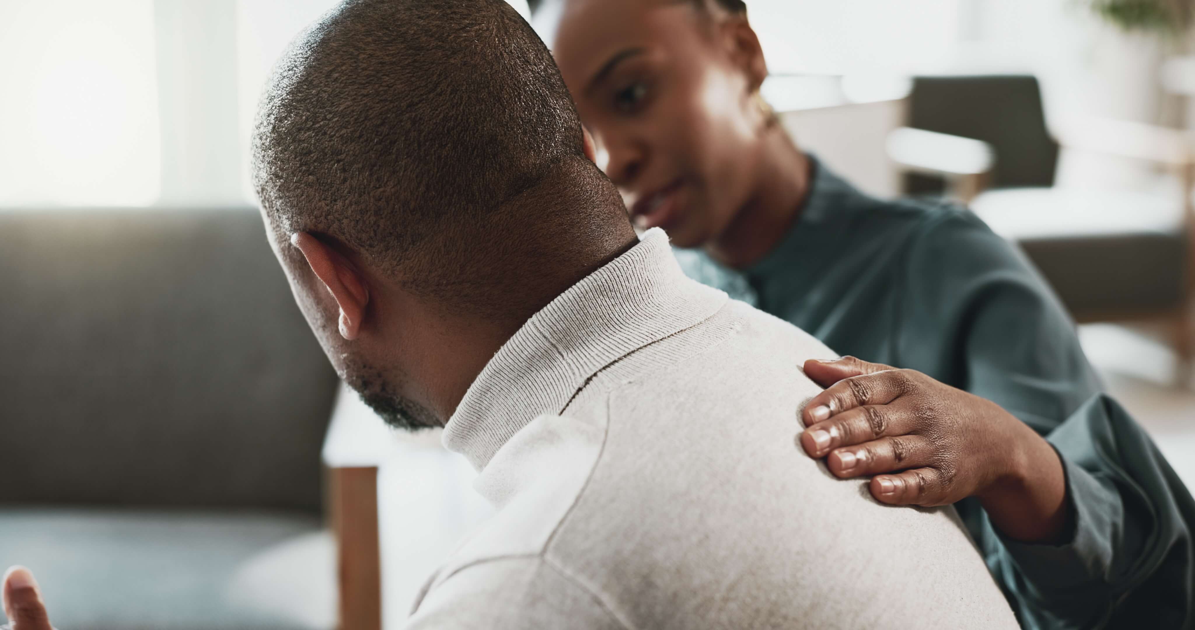 African-American man being comforted by a woman.