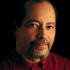 A portrait of a man against a dark background.