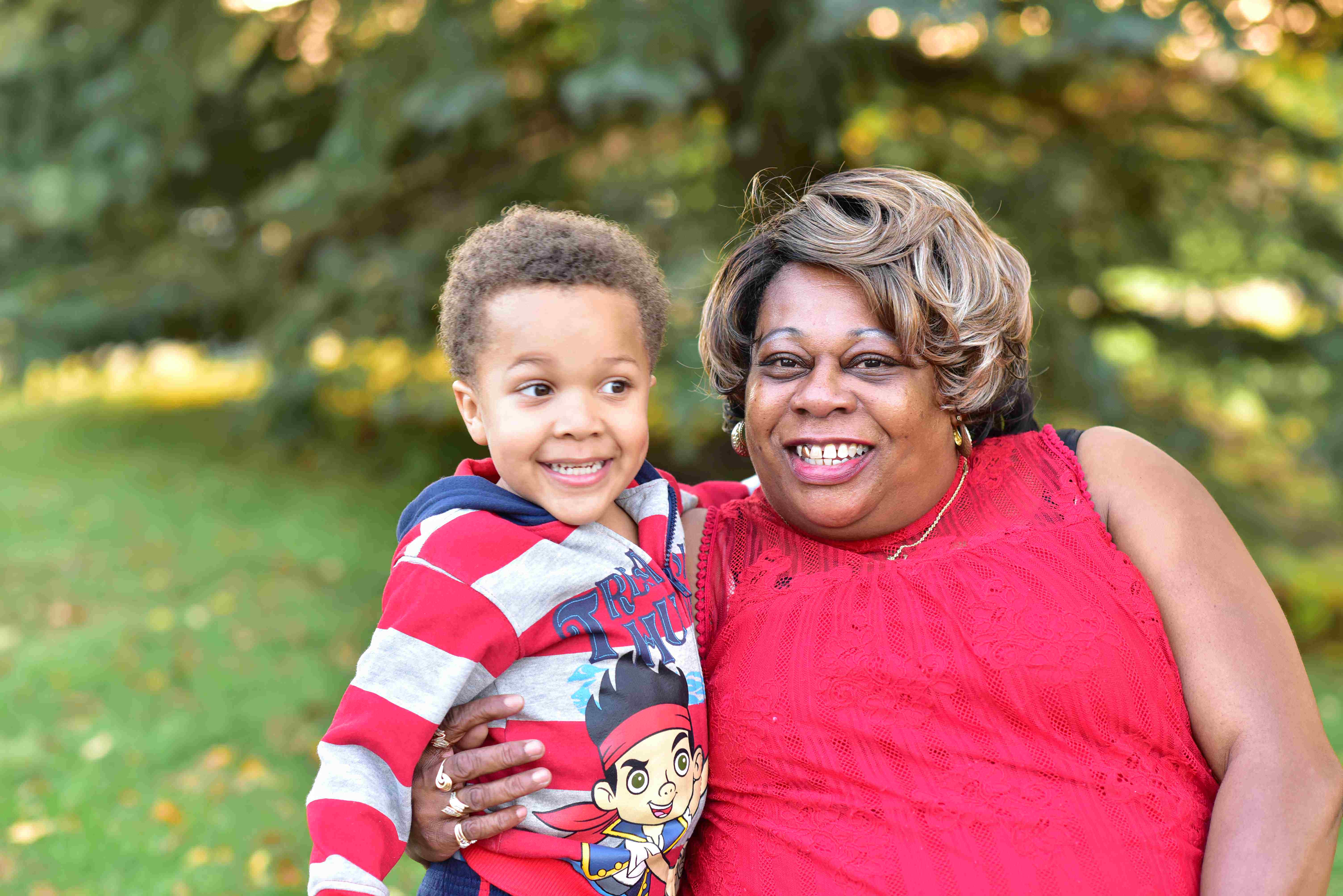 A grandma and her grandson smiling in a park.