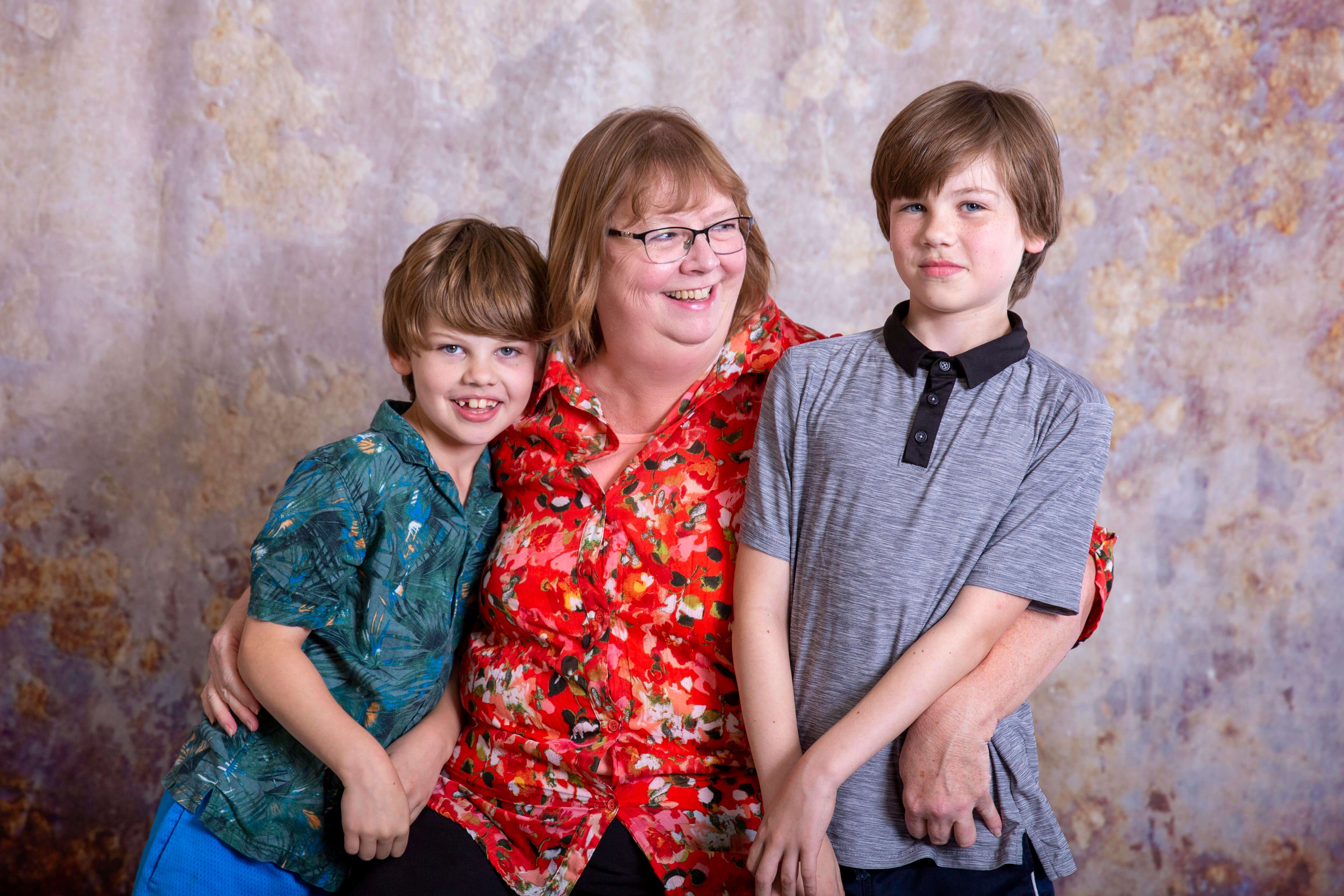 A mother and her two children hugging and smiling