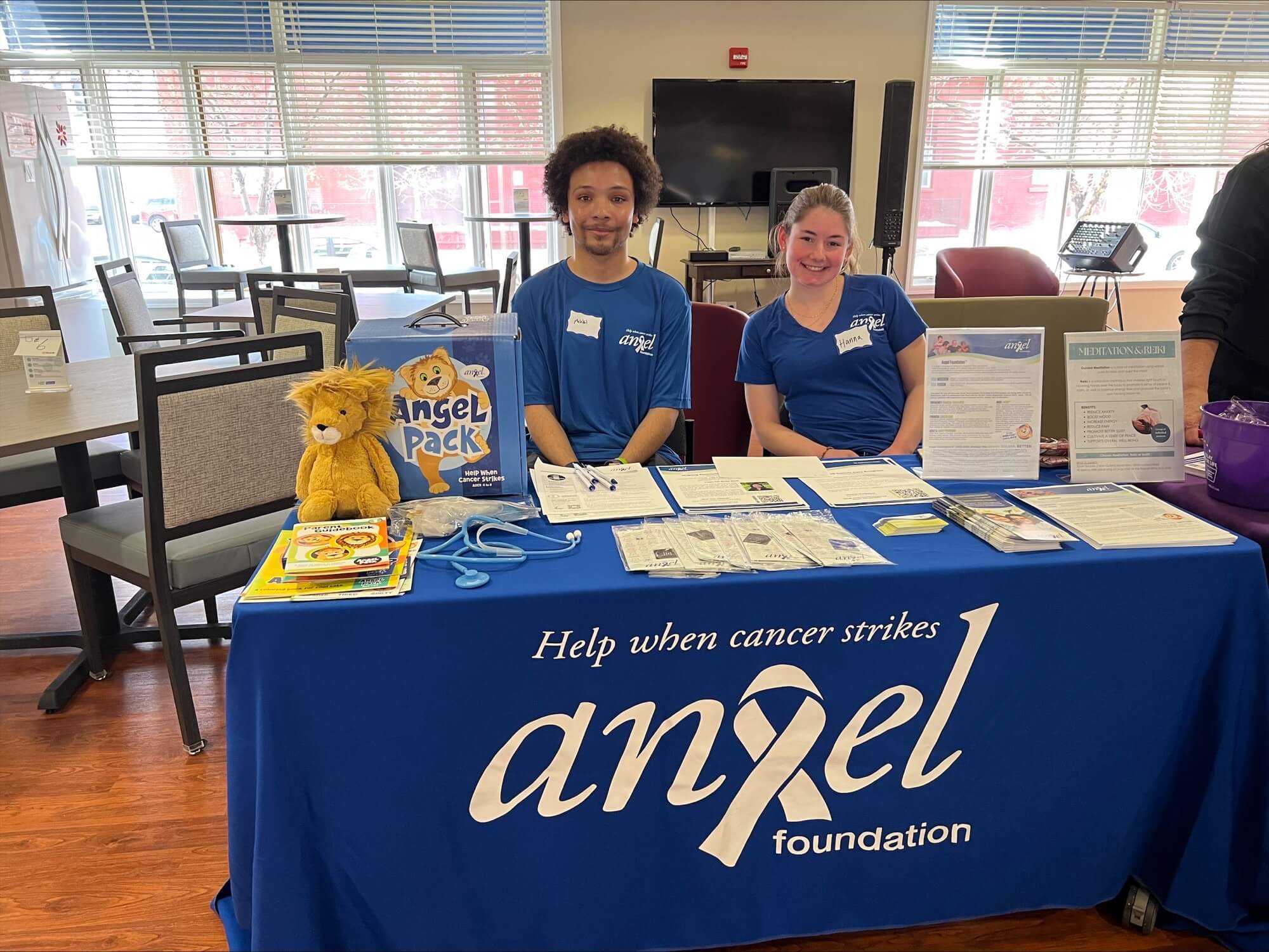Two young people sit at an Angel Foundation table.