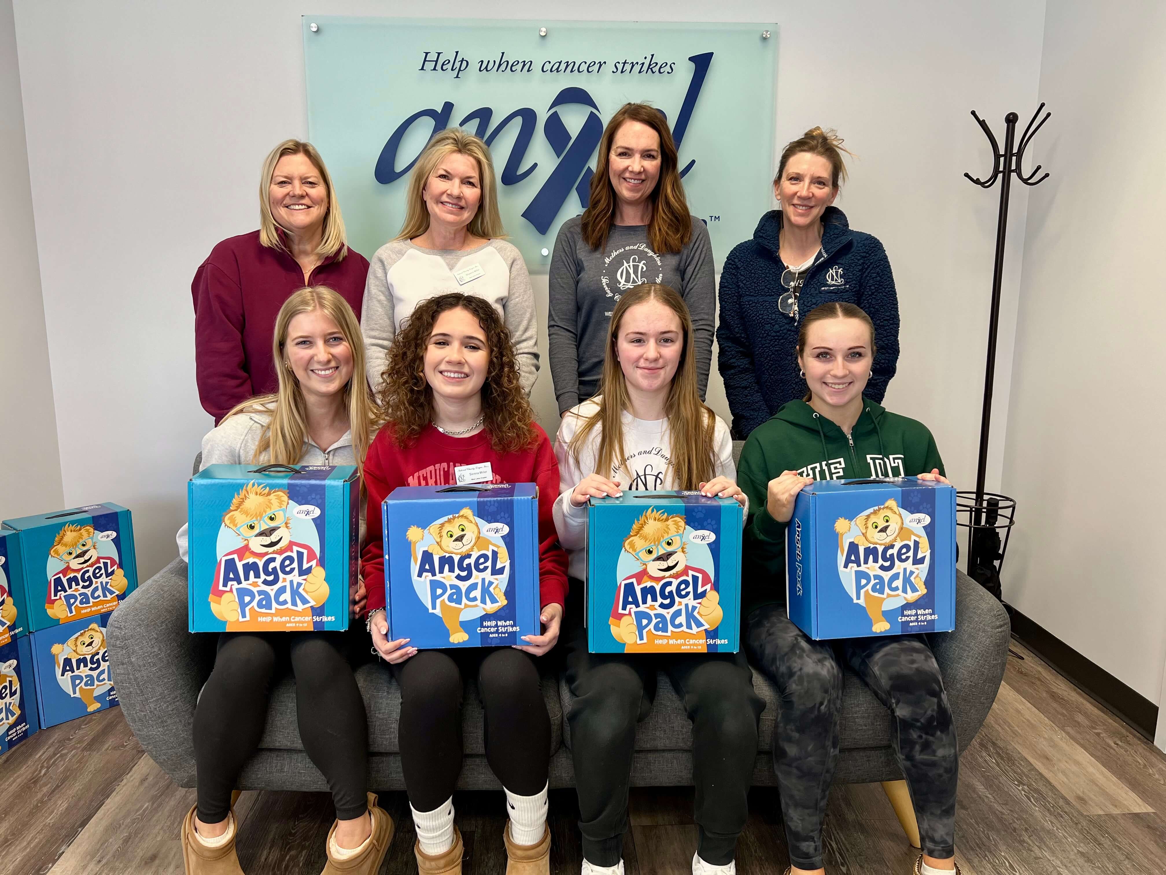 A group of young women hold Angel Packs and smile.