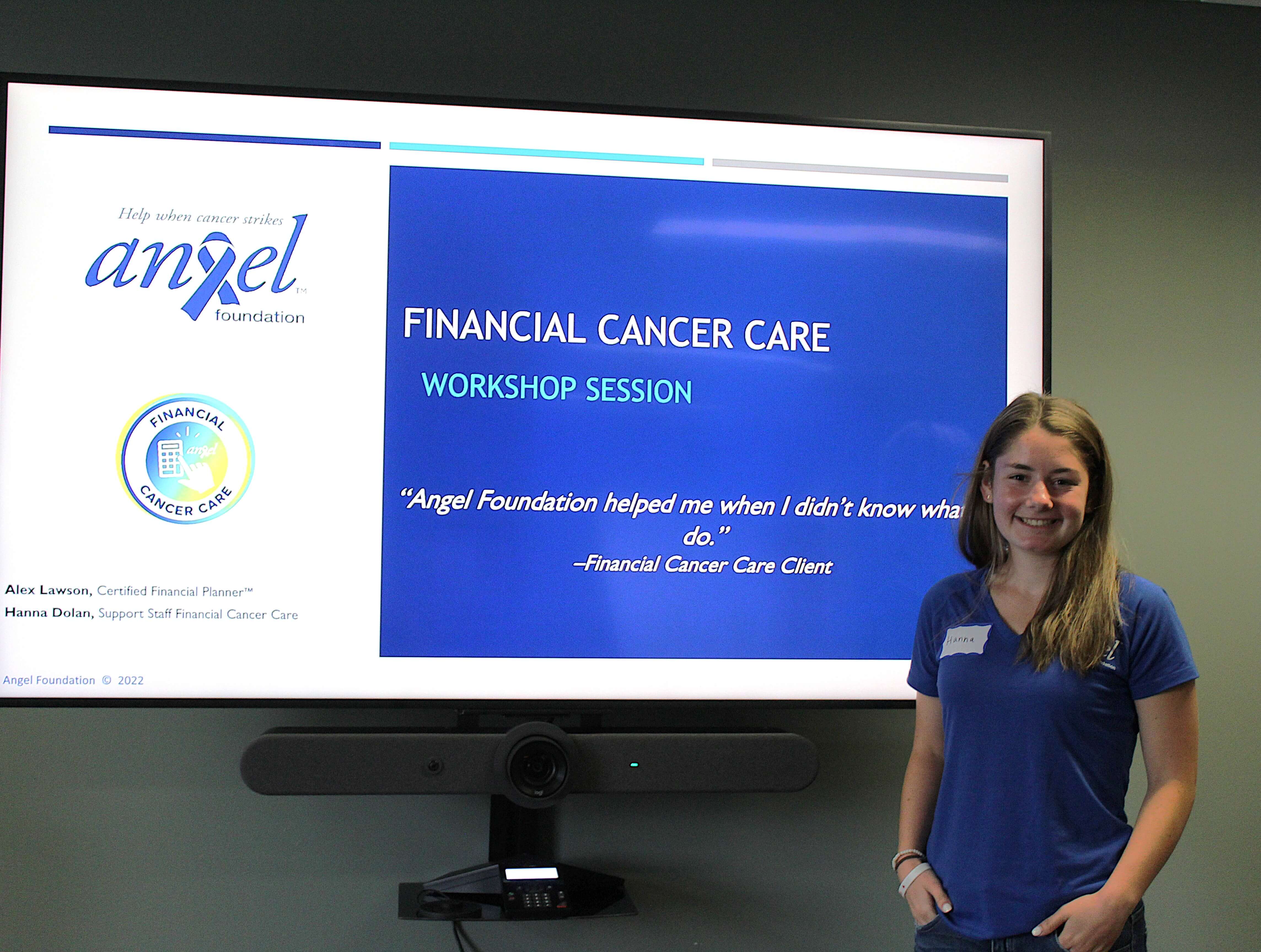 A photo of a smiling woman in front of a board that reads 