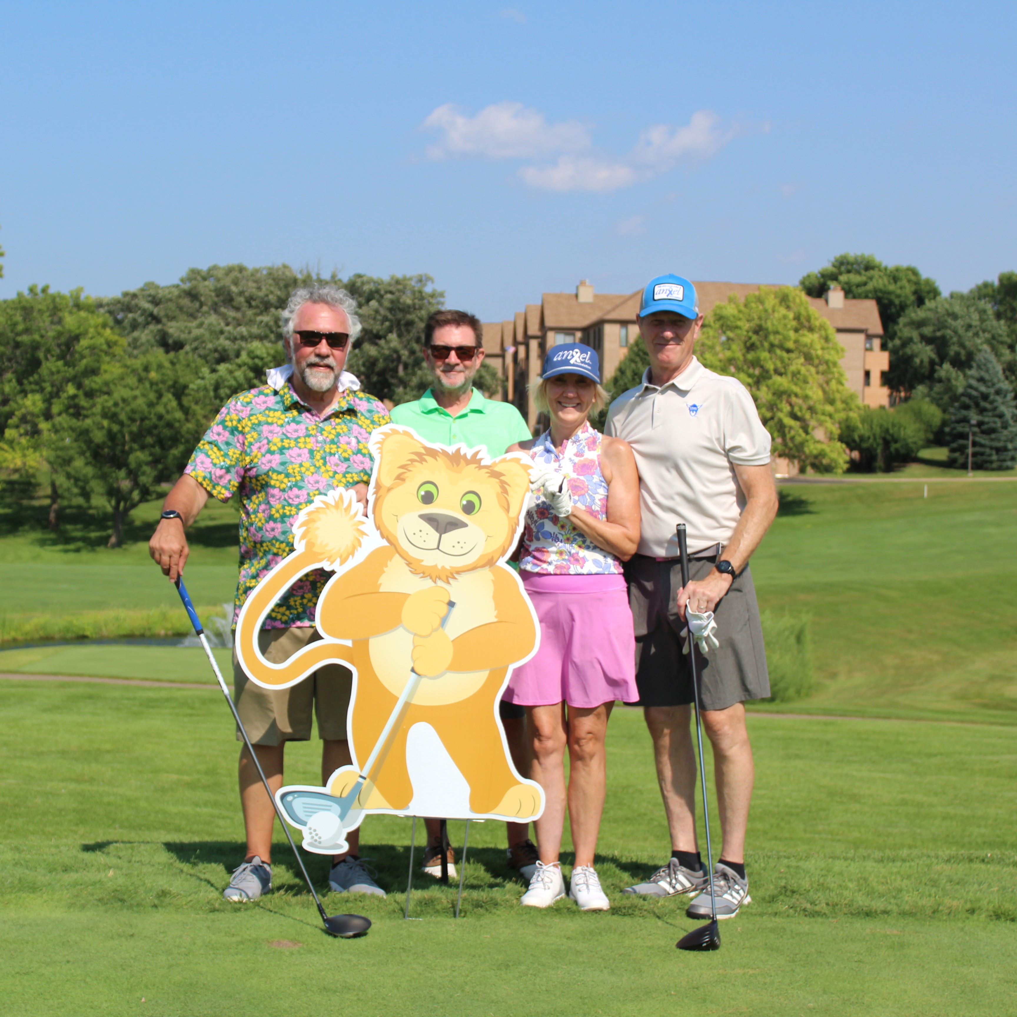 Smiling golfers holding golf balls dedicated to those impacted by cancer